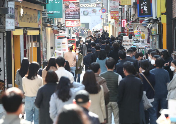 다음달부터 본격 시행되는 ‘단계적 일상회복(위드코로나)' 방역체계 전환을 앞둔 25일 오후 서울 명동 거리에서 점심식사를 하려는 시민들로 붐비고 있다. 연합뉴스