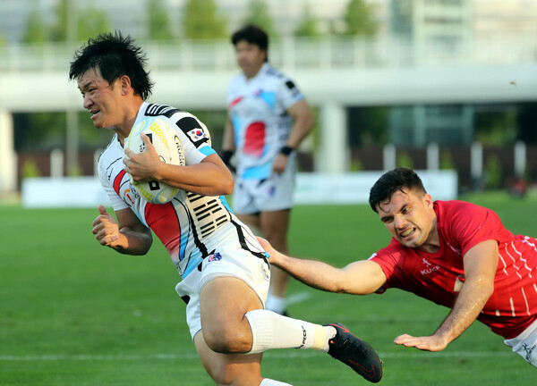 한국 15인제 럭비대표팀의 주장 김광민이 9일 오후 인천 남동아시아드 럭비경기장에서 열린 2022 아시아 럭비 챔피언십 결승전에서 홍콩 선수를 따돌리고 트라이에 성공하고 있다. 인천/연합뉴스