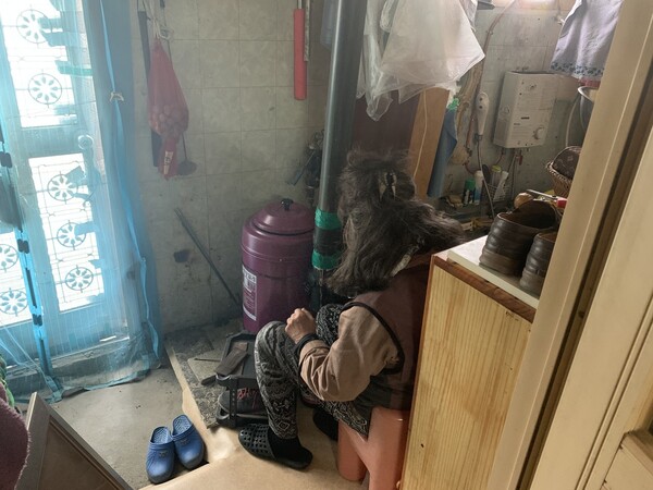 서울 강남구에 있는 쪽방촌 구룡마을 주민 이아무개씨가 집 안 난로 앞에 앉아 있다. 김윤주 기자