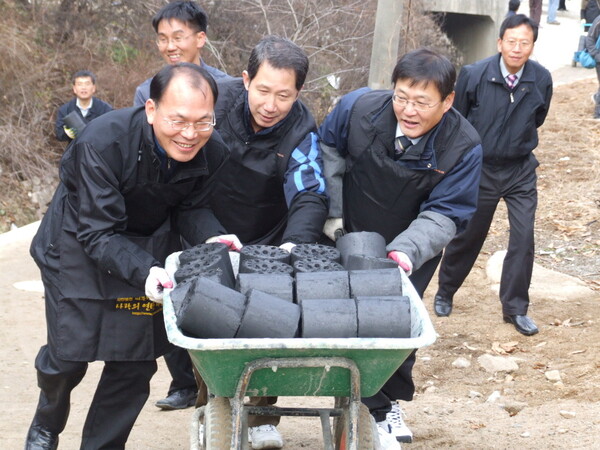 지난 2006년 12월 서울 부암동에서 연탄 배달 자원봉사 중인 고 김근태(가운데) 열린우리당 의장과 이동섭(맨오른쪽) 이사장. 사랑의연탄나눔운동 제공