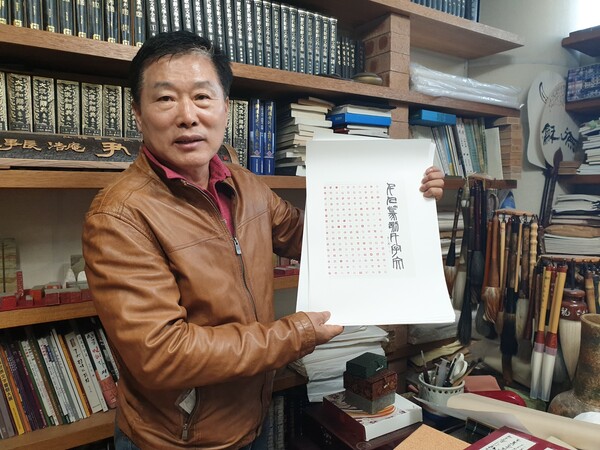 호암 윤점용 집행위원장이 자신의 서재에서 인쇄된 여러장의 ‘천인전각천자문’을 들고서 설명하고 있다.