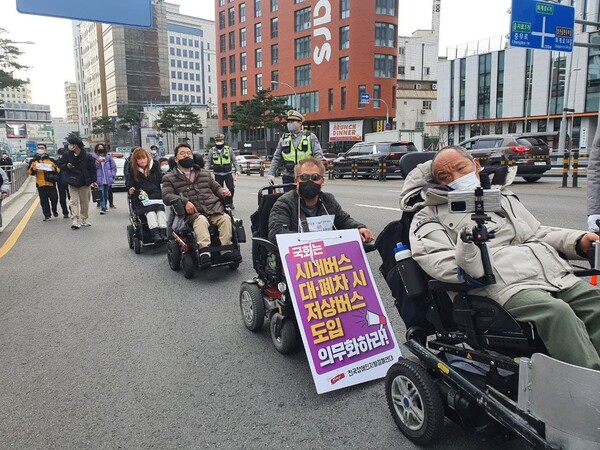 9일 이규식 서울장애인차별철폐연대 공동대표(가장 오른쪽) 등 전국장애인차별철폐연대 활동가들이 국가인권위원회 진정에 앞서 서울 지하철 4호선 충무로역 인근에서 행진을 하고 있다. 장현은 기자 mix@hani.co.kr