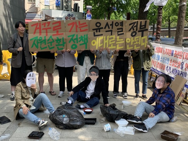 한국환경회의 활동가들이 4일 서울 종로구 대통령직인수위원회 앞에서 기자회견을 열고 윤석열 대통령 당선자의 자원순환정책을 비판하는 퍼포먼스를 하고 있다. 김윤주 기자