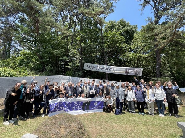 지난 6월11일 경기도 남양주시 마석 모란공원 문익환·정경모·유원호 선생 묘역에서 열린 ‘모란통일동산’ 추모벽 제막식 참가자들이 함께 기념사진을 찍었다.  6월항쟁계승사업회 제공