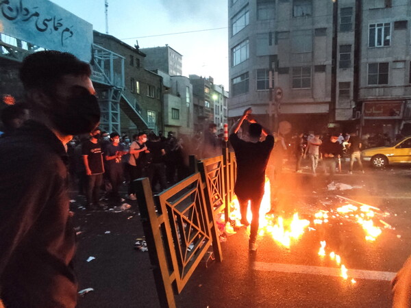 20대 여성이 히잡을 쓰지 않았다는 이유로 조사받아 숨진 사건에 항의하는 시위대가 21일 테헤란에서 진압경찰과 충돌하고 있다. 테헤란/EPA 연합뉴스