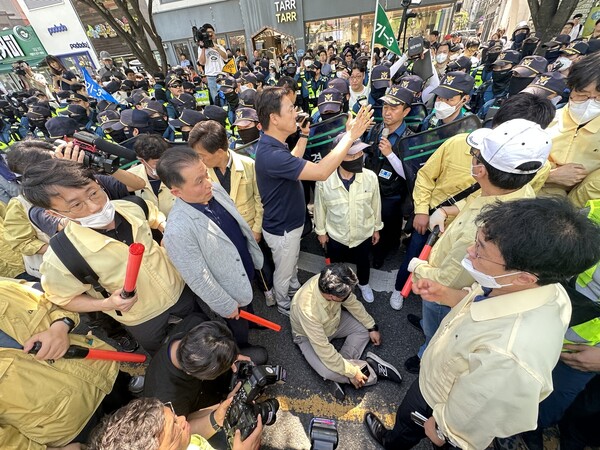 17일 오전 대구 중구 반월당역 인근에서 퀴어문화축제 쪽 무대차량 진입을 위해 교통정리에 나선 경찰관들과 이를 막으려는 대구시 공무원들이 대치한 가운데 대구시 한 간부 공무원이 부상을 주장하며 바닥에 앉아 있다. 연합뉴스