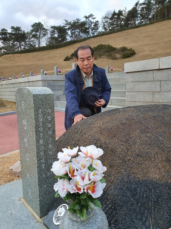 5·18민주유공자 이동춘 목포과학대 교수가 지난 27일 국립5·18민주묘지를 찾아 4살 아이가 묻힌 무명열사 무덤에서 참배하고 있다.