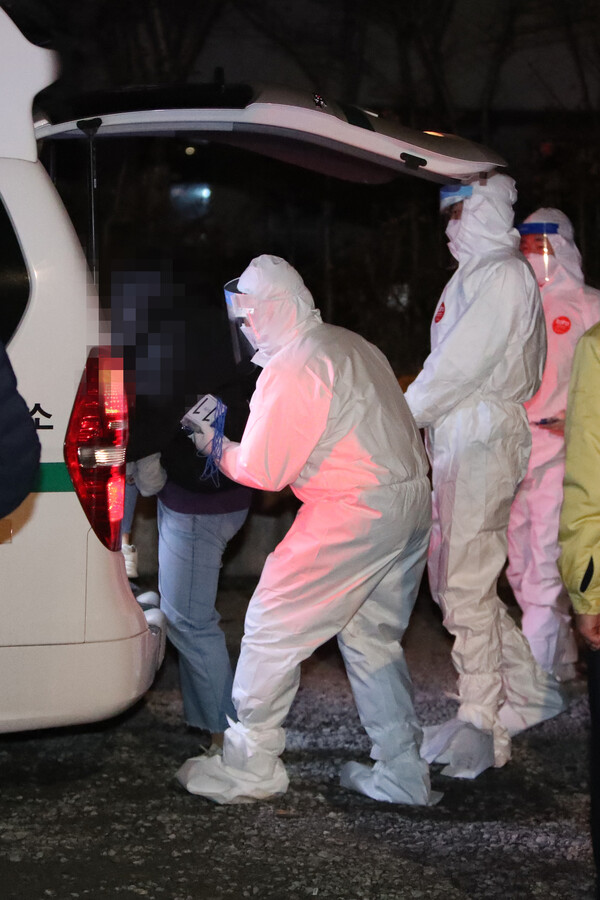 지난달 27일 오전 광주시 광산구 운남동 광주TCS국제학교에서 방역당국 관계자가 코로나19 음성 판정을 받은 합숙생을 격리 시설로 이송하고 있다. 연합뉴스