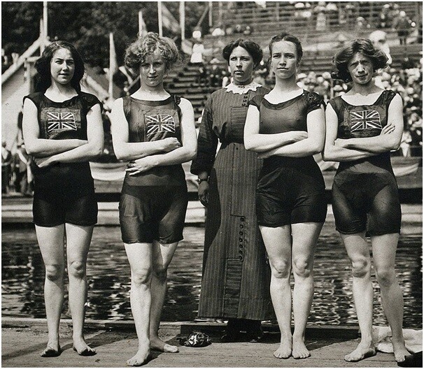 5회 올림픽 수영 계주에서 우승을 거둔 영국의 여성 선수들과 목에서 발까지 이르는 어두운 색의 드레스를 입고 있는 여성(가운데)이 묘한 대조를 보이고 있다. 위키미디어 코먼스 제공