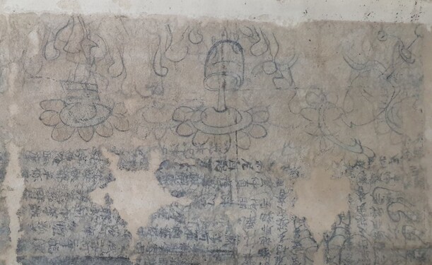 경주 남산 출토로 전해지는 범자본 수구다라니의 부분. 연꽃무늬와 정병의 도상들을 글자 위에 그려놓았다.