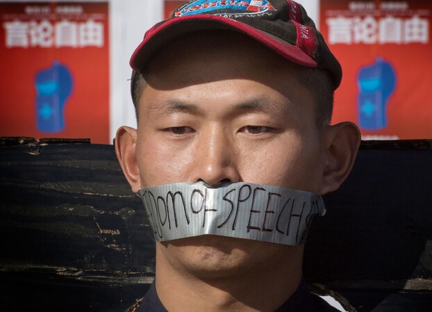 미국 로스앤젤레스 캘리포니아대(UCLA)에서 15일 중국인 학생이 ‘코로나 19’ 발병 사실을 처음으로 세상에 공개한 의사 리원량 추모식에서 언론을 통제하고 있는 중국 정부에 대한 항의 뜻을 담아 입에 ‘언론의 자유’라고 적힌 테이프를 붙이고 있다. 로스앤젤레스/AFP 연합뉴스