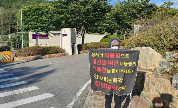 배아무개씨가 경기 파주의 스마트 케이유(KU) 파빌리온 골프장 앞에서 직장 내 괴롭힘으로 죽음에 이른 동생 죽음의 진상을 밝혀달라며 시위를 벌이는 모습. 직장갑질119 제공