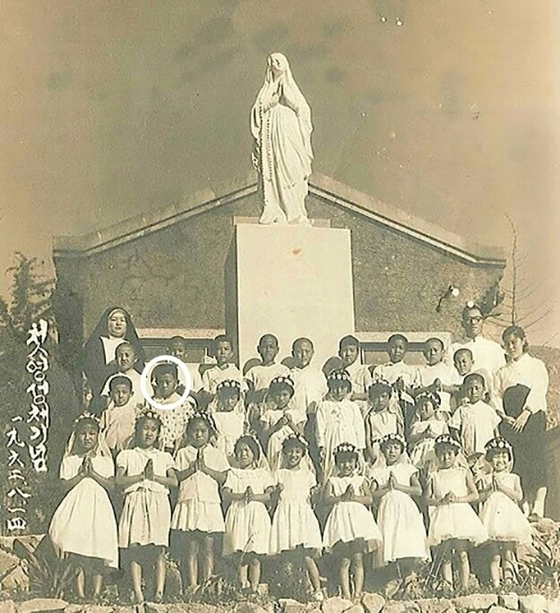 문재인 대통령이 초등학교 3학년 때인 1962년 첫 영성체를 한 뒤 기념촬영한 모습. 둘째줄 왼쪽에서 두번째 동그라미 속 학생이 문 대통령. 문재인 대통령 가족 제공.