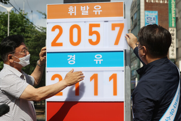 정부가 유류세 인하폭을 확대하기로 한 1일 오전 서울 강서구 알뜰목화주유소에서 박일준 산업통상자원부 제2차관(오른쪽)이 유가정보판을 교체하고 있다. 연합뉴스