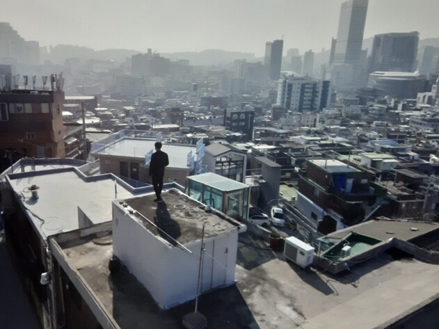 전시의 핵심 출품작인 25분짜리 영상물 &lt;절망하고 탄생하라&gt; 후반부의 ‘파쿠르’(자유이동 기술)를 시작하는 장면. 서울 도심이 내려다보이는 창신동 고지대 달동네의 옥상과 골목길 사이를 장애물을 활용해 자유롭게 이동하는 탈주의 몸짓을 보여준다.