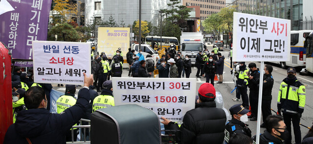 제1517차 일본군성노예제 문제해결을 위한 정기 수요시위가 서울 종로구 연합뉴스 앞에서 열린 지난해 11월10일 낮 국사교과연구소, 위안부법폐지국민행동 활동가들의 모습과 손팻말 너머로 수요시위 현장이 보이고 있다. 김혜윤 기자 unique@hani.co.kr