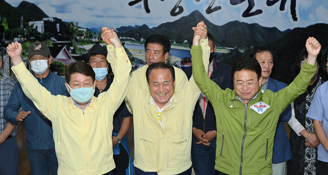 권영진 대구시장, 김영만 경북 군위군수, 이철우 경북도지사가 30일 저녁 군위군청 대회의실에서 함께 손을 들며 기뻐하고 있다. 대구시 제공