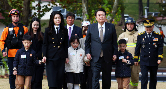 윤석열 대통령과 김건희 여사가 9일 서울 용산구 용산어린이정원 잔디마당에서 열린 ‘제61주년 소방의 날 기념식’에 순직 소방관 자녀들의 손을 잡고 입장하고 있다. 연합뉴스