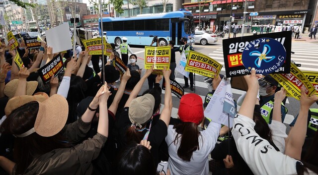 16개월 된 입양아 정인이를 학대해 숨지게 한 혐의를 받는 양부모의 1심 선고 공판이 열린 14일 오전 서울 양천구 서울남부지법 앞에서 시민들이 양모 장씨가 탄 것으로 보이는 호송차를 향해 손팻말을 들고 항의하고 있다. 연합뉴스