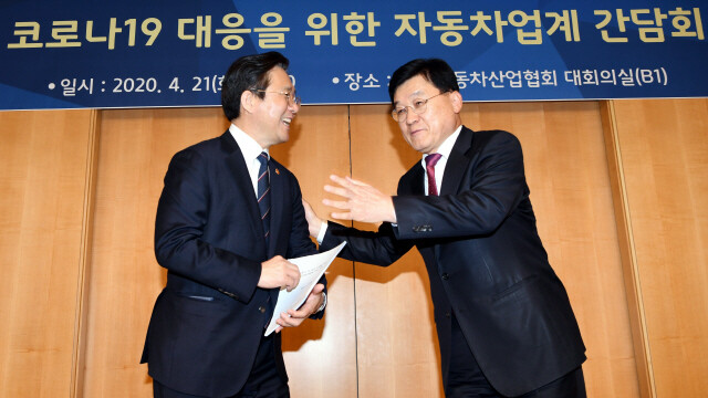 정만기 자동차산업협회장(오른쪽)이 지난달 21일 오후 서울 서초구 자동차산업협회에서 열린 코로나19 대응을 위한 자동차업계 간담회에서 성윤모 산업통상자원부 장관에게 긴급 건의사항을 전달하고 있다. 공동취재사진단