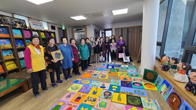 광주 복합문화공간 메이홀은 10일부터 31일까지 ‘오월 어머니들의 그림농사’라는 주제로 5·18 특별전시회를 연다. 양림동 오월어머니집에서 어머니들이 그린 작품을 들고 있다. 주홍 작가 제공