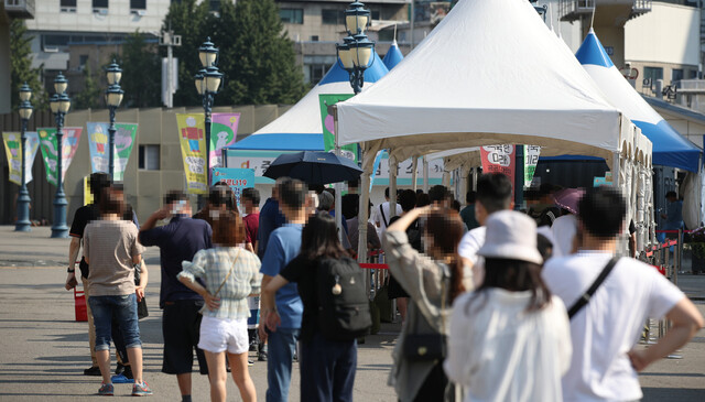 23일 오전 서울역 광장에 마련된 중구임시선별검사소에서 시민들이 검사를 받기 위해 줄을 서 있다. 연합뉴스