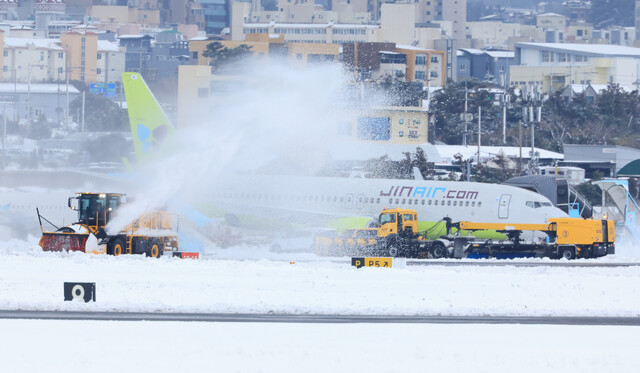 폭설이 내린 22일 오후 제주국제공항 활주로에서 제설차량이 눈을 치우고 있다. 연합뉴스