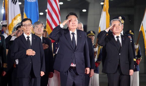 윤석열 대통령이 26일 밤 경기도 성남시 서울공항에 도착한 한국전쟁 국군전사자 유해에 경례하고 있다. 연합뉴스