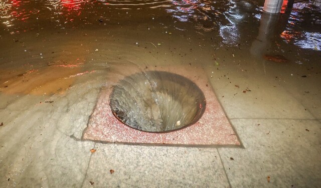 지난 9일 새벽 폭우로 다수의 차량이 침수된 서울 강남구 대치사거리의 배수구가 맨홀 뚜껑이 없어진 채 소용돌이치고 있다. 연합뉴스