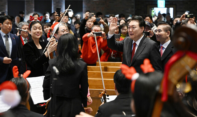 윤석열 대통령이 성탄절인 25일 서울 중구 정동제일교회에서 열린 성탄예배에서 오케스트라 공연단을 격려하고 있다. 대통령실 제공