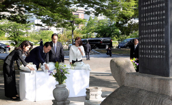 윤석열 대통령과 김건희 여사가 21일 히로시마 평화기념공원 내 한국인 원폭 피해자 위령비에 기시다 후미오 일본 총리, 유코 여사와 함께 헌화하고 있다. 연합뉴스