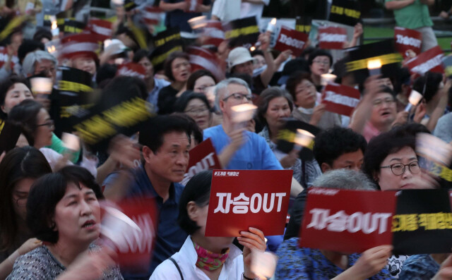 지난 2017년 7월 서울 종로 종각 앞에서 열린 조계종적폐청산촛불집회에서 참가자들이 자승아웃 등의 손팻말을 흔들며 조계종의 적폐 청산을 촉구하고 있다. 사진 백소아 기자