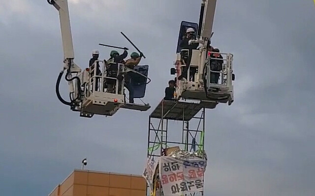 31일 새벽 전남 광양시 포스코 광양제철소 앞 고공농성장에서 경찰과 소방대원이 농성하던 한국노총 금속노련 간부를 진압봉으로 제압하고 있다. 한국노총 동영상 갈무리