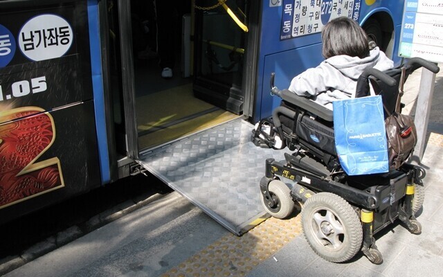 서울 성북구청 근처 버스 정류장에서 한 장애인이 272번 저상버스에 오르려 한다. 한겨레