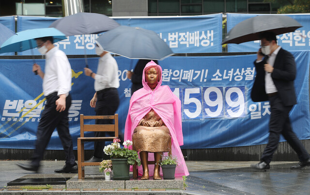 더불어시민당 윤미향 당선자의 ‘후원금 회계 논란’이 불거진 가운데 비가 내린 지난 15일 서울 종로구 옛 일본대사관 앞에 설치된 평화의 소녀상에 우비가 입혀져 있다. 연합뉴스