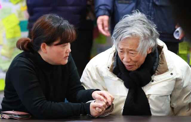 백기완 통일문제연구소장(오른쪽)이 2019년 1월24일 서울 종로구 연건동 서울대병원 장례식장에 마련된 고 김용균씨의 빈소 접객실에서 열린 사회원로 중진 비상시국선언 기자회견에 참석해 김용균 씨 어머니 김미숙 씨의 손을 잡고 있다. 연합뉴스