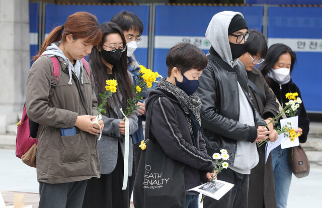 13일 오후 서울 광화문광장에서 '애도와 민주주의의 길 걷기' 참가자들이 광화문광장 곳곳에 있는 기억과 추모의 공간을 함께 걷기에 앞서 묵념하며 이태원 참사 희생자들을 애도하고 있다. 신소영 기자 viator@hani.co.kr