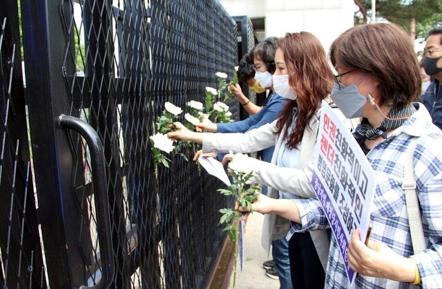 정의당 충남도당과 충남 지역 50여개 시민단체 회원들이 지난 4일 공군 성추행 사건이 발생한 충남 서산 공군 20전투비행단 앞에서 병영문화 개선과 철저한 수사를 촉구하는 기자회견을 한 뒤 고인이 된 피해자를 애도하며 비행단 정문에 국화를 꽂고 있다. 서산/연합뉴스