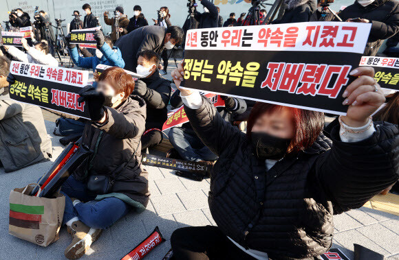 22일 오후 서울 종로구 광화문 시민열린마당에서 소상공인연합회와 코로나19 대응 전국자영업자비상대책위원회가 개최한 ‘소상공인·자영업자 생존권 결의대회’에서 참석자들이 손팻말을 들며 구호를 외치고 있다. 연합뉴스