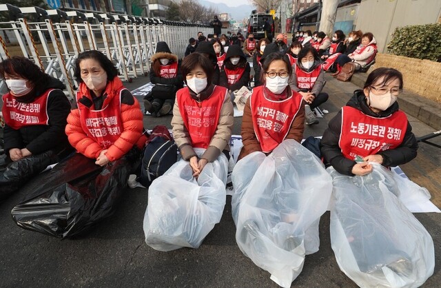 덕성여대와 공공운수노조 서울지부 소속 청소노동자들이 지난 2월 7일 오후 서울 종로구 덕성여대 종로캠퍼스 앞에서 바닥 냉기를 막기 위해 비닐 봉투로 다리를 감싸며 김건희 총장 규탄 집회를 열고 있다. 강창광 선임기자