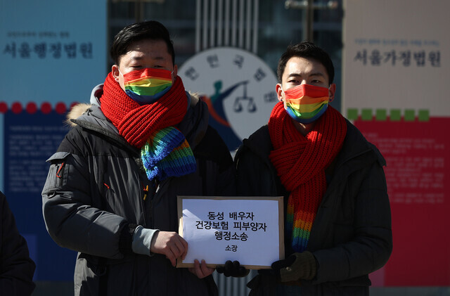 지난 2월 서울 서초구 서울행정법원 앞에서 열린 '동성 배우자 건강보험 피부양자 소송 기자회견'에서 소송 당사자 소성욱(왼쪽)·김용민씨 부부가 소장을 들어 보이고 있다. 연합뉴스