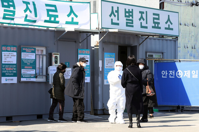 19일 오후 대구광역시 서구 대구의료원 선별진료소 의료진이 코로나19 확진 검사를 문의하는 이들에게 “지금은 검사가 안 된다”고 말하며 손으로 X 표시를 하고 있다. 이날 대구의료원에는 의심환자가 몰리며 코로나19 확인 검사가 늦어졌다. 연합뉴스.