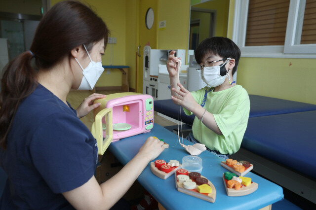 쌍둥이 형 도현이가 작업치료사와 함께 찰흙을 가지고 놀며 손힘을 기르는 치료를 받고 있다. 강창광 선임기자 chang@hani.co.kr