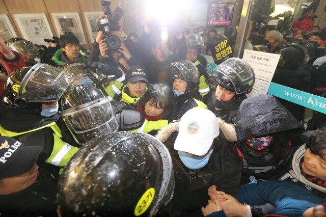 2013년 12월22일 오전, 경찰이 김명환 위원장 등 철도노조 집행부의 체포영장을 강제집행하겠다며 민주노총이 세들어 있는 서울 중구 정동 경향신문사 건물 1층 로비에서 출입문을 뜯어내고 최루액을 발사하고 있다. 한겨레 자료사진