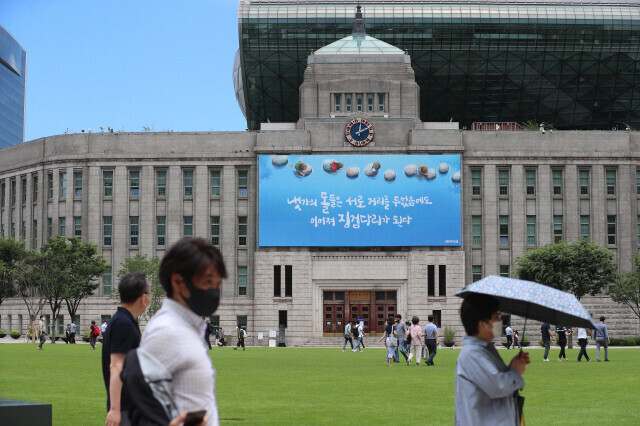 지난해 7월15일 서울시청 광장 오가는 시민들 뒤로 서울시청 건물이 보인다. 강창광 선임기자 chang@hani.co.kr