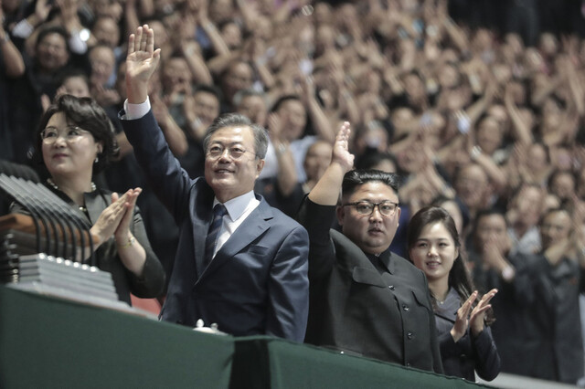 문재인 대통령과 김정은 국무위원장이 2018년 19일 밤 평양 5.1경기장에서 열린 남북정상회담 경축 대집단체조와 예술공연 ‘빛나는 조국’에 입장한 뒤 손을 들어 인사하고 있다. 평양사진공동취재단