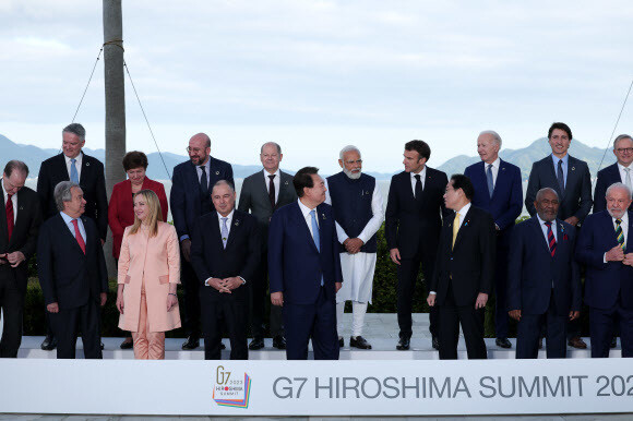 주요 7개국(G7) 정상회의에 참관국 자격으로 참석한 윤석열 대통령이 20일 일본 히로시마 그랜드 프린스 호텔에서 열린 정상회의 확대회의 중간 각국 정상들과 기념촬영을 하며 대화하고 있다. 연합뉴스