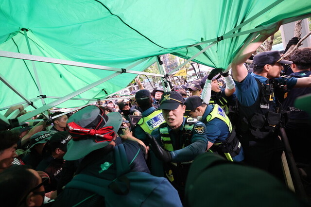 ‘양회동 열사 투쟁 노동시민사회종교문화단체 공동행동’ 주최로 지난달 31일 오후 서울 중구 파이낸스빌딩 앞에서 열린 추모 촛불문화제에서 참석자들이 천막 분향소를 설치하자 경찰들이 강제 철거하고 있다. 신소영 기자 viator@hani.co.kr