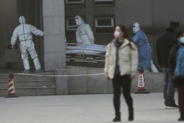 지난 20일(현지 시각), 중국 후베이성 우한 지역 의료진이 전염병 전문 치료기관인 진인 탄 병원으로 환자를 옮기고 있다. 우한/로이터 연합뉴스