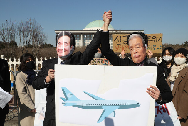 지난 9일 국회 앞에서 열린 가덕도 신공항 특별법 반대 기자회견에서 청년기후긴급행동 등 단체 회원들이 이낙연 더불어민주당 대표와 김종인 국민의힘 비대위원장 얼굴 가면을 쓰고 ‘신공항 특별법 반대 퍼포먼스’를 하고 있다. 연합뉴스